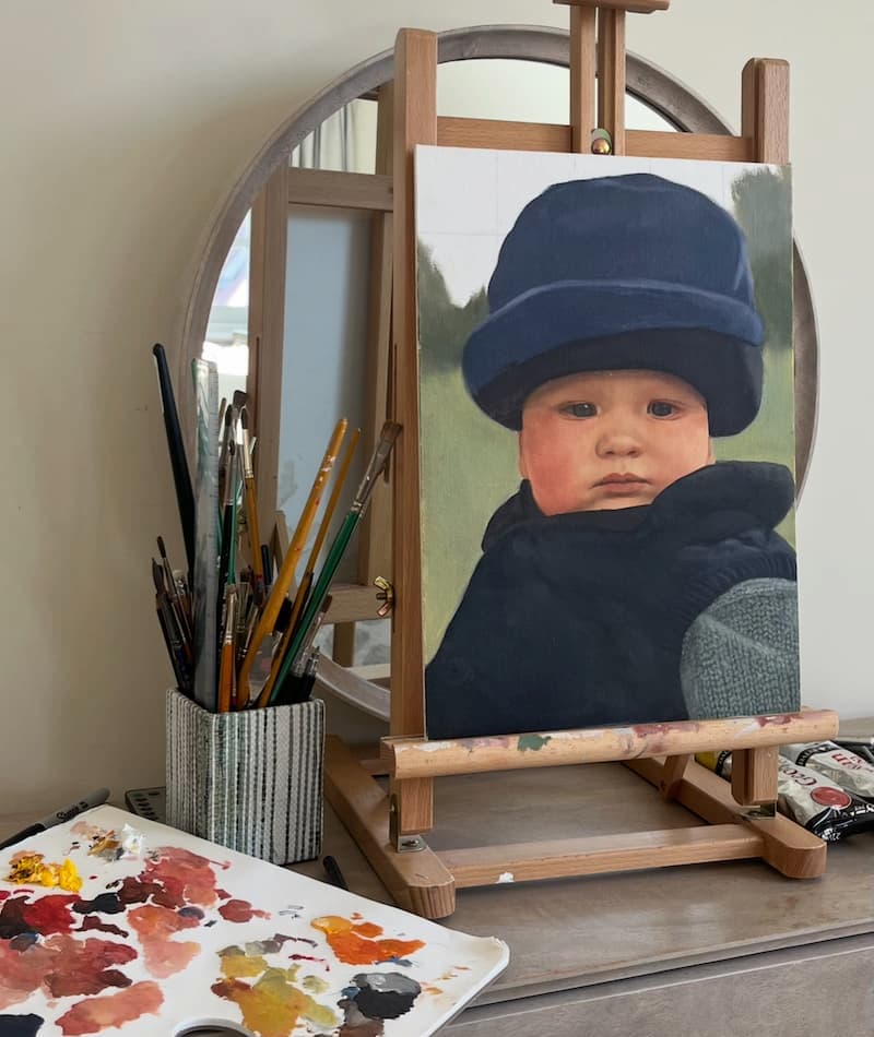 Portrait study of a baby in the studio, work-in-progress on the easel